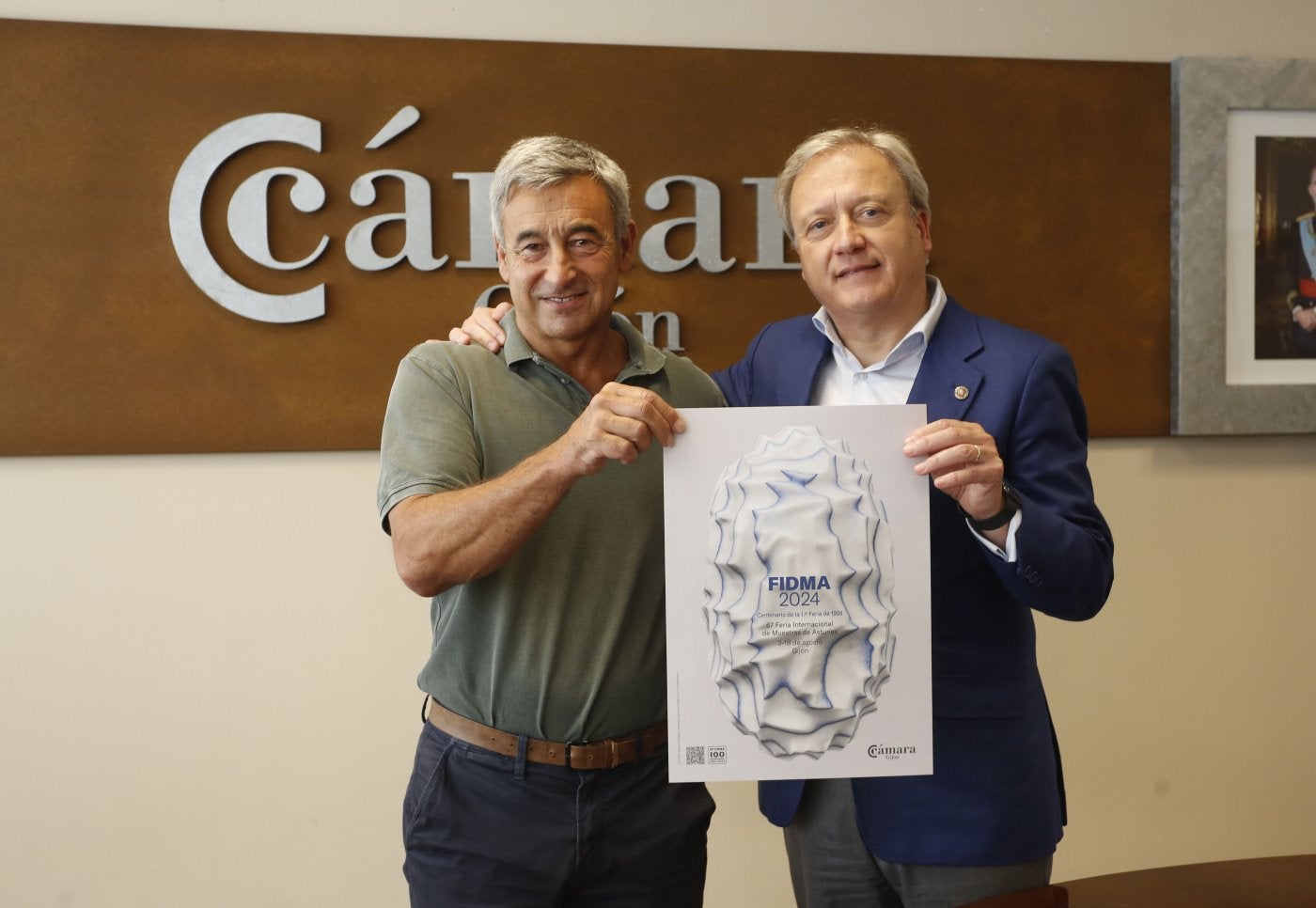 Mario Cueto-Felgueroso, director comercial de la Fidma, y Álvaro Alonso Ordás, director, en la sede de la Cámara de Comercio de Gijón con el cartel de la 67 edición.