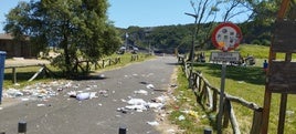 Entrada a la playa de Carranques, en Perlora, llena de basura.