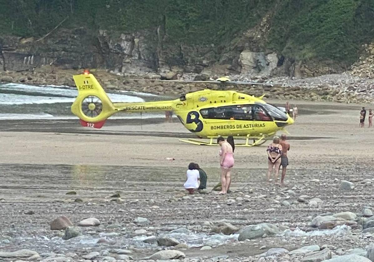 Varias personas se lamentan por lo ocurrido, ante el helicóptero de rescate de Bomberos, en la Concha de Artedo.