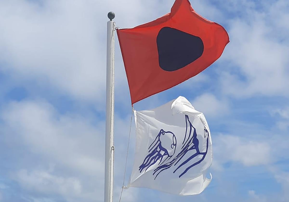 Bandera roja que ondea en la escalera 7 de la playa de San Lorenzo y prohibe el baño en esa zona.