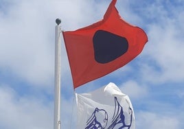 Bandera roja que ondea en la escalera 7 de la playa de San Lorenzo y prohibe el baño en esa zona.