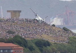 El avión CN235 que la Guardia Civil dedica a la vigilancia marítima pasa frente el cerro de Santa Catalina, abarrotado de público.