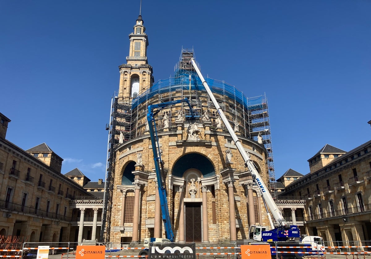 Un grúa instalando el armazón de la replica de la Cruz de la Victoria sobre la entrada de la iglesia de la Laboral