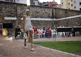 Una de las modelos de Piano B luce un vestido blanco decorado con plumas.