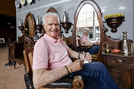 Ramiro Fernández, en una de las sillasde su Museo de la Barbería que exponeen el Palacio de Congresos.