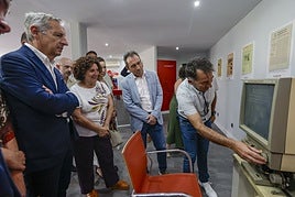 Hemeroteca.Ángel González muestra a Ovidio Zapico y Beatriz González elfuncionamiento de una lectorade microfilms.