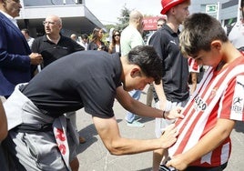 Nacho Martín firma la camiseta del joven aficionado Manuel Sánchez García, ayer, en el stand de Cyasa Nissan en la Feria de Muestras de Gijón.