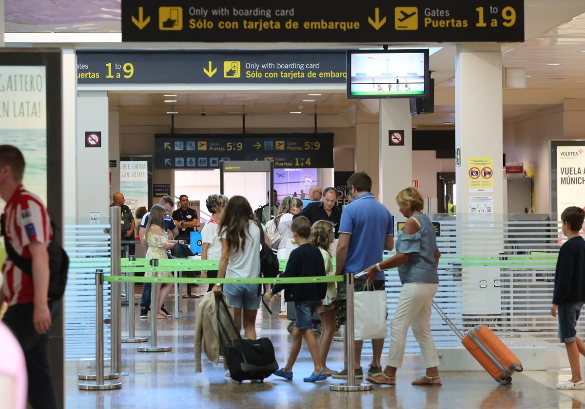 Pasajeros a su paso por el control de viajeros del aeropuerto de Asturias.