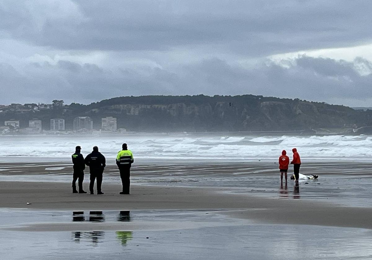 Dos socorristas, junto al cuerpo en San Juan, observados por Policía y Guardia Civil.