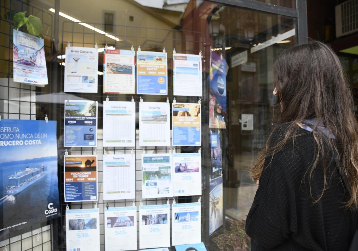 Una joven observa las ofertas en una agencia de viajes de Avilés.