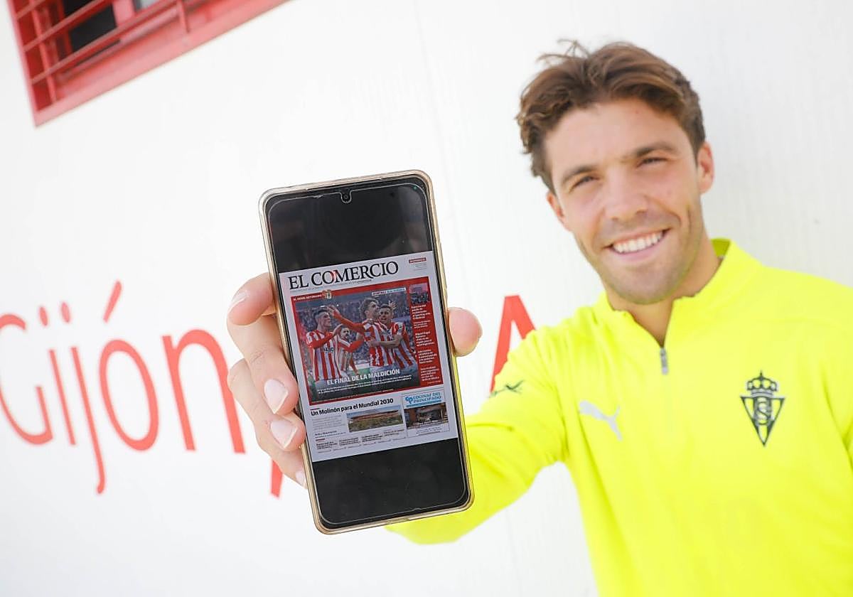 Nacho Méndez, ayer, sujetando un móvil con la portada de EL COMERCIO del último derbi, con la fotografía de la celebración de su gol.