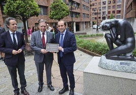 Nacho Cuesta, Alfredo Canteli y Marcos Óscar Martínez, con la placa de la plaza Graduados Sociales y la estatua de Santiago de Santiago.