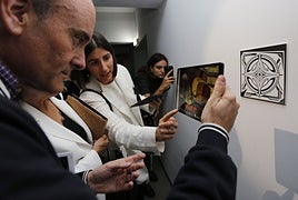 Pablo León observa en la tableta una obra de Clara Peeters y atiende a las explicaciones de la comisaria, Begoña Torre.