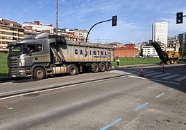 Un camión y una fresadora trabajan sobre el asfalto para hacer el nuevo carril-bici.