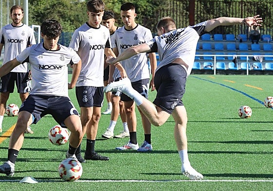 Los juveniles Dani y Macías, en primer plano en el entrenamiento del Avilés ayer en La Toba.