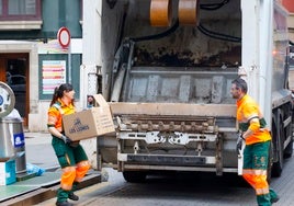 Operarios de Emulsa recogiendo basura en una céntrica calle gijonesa.