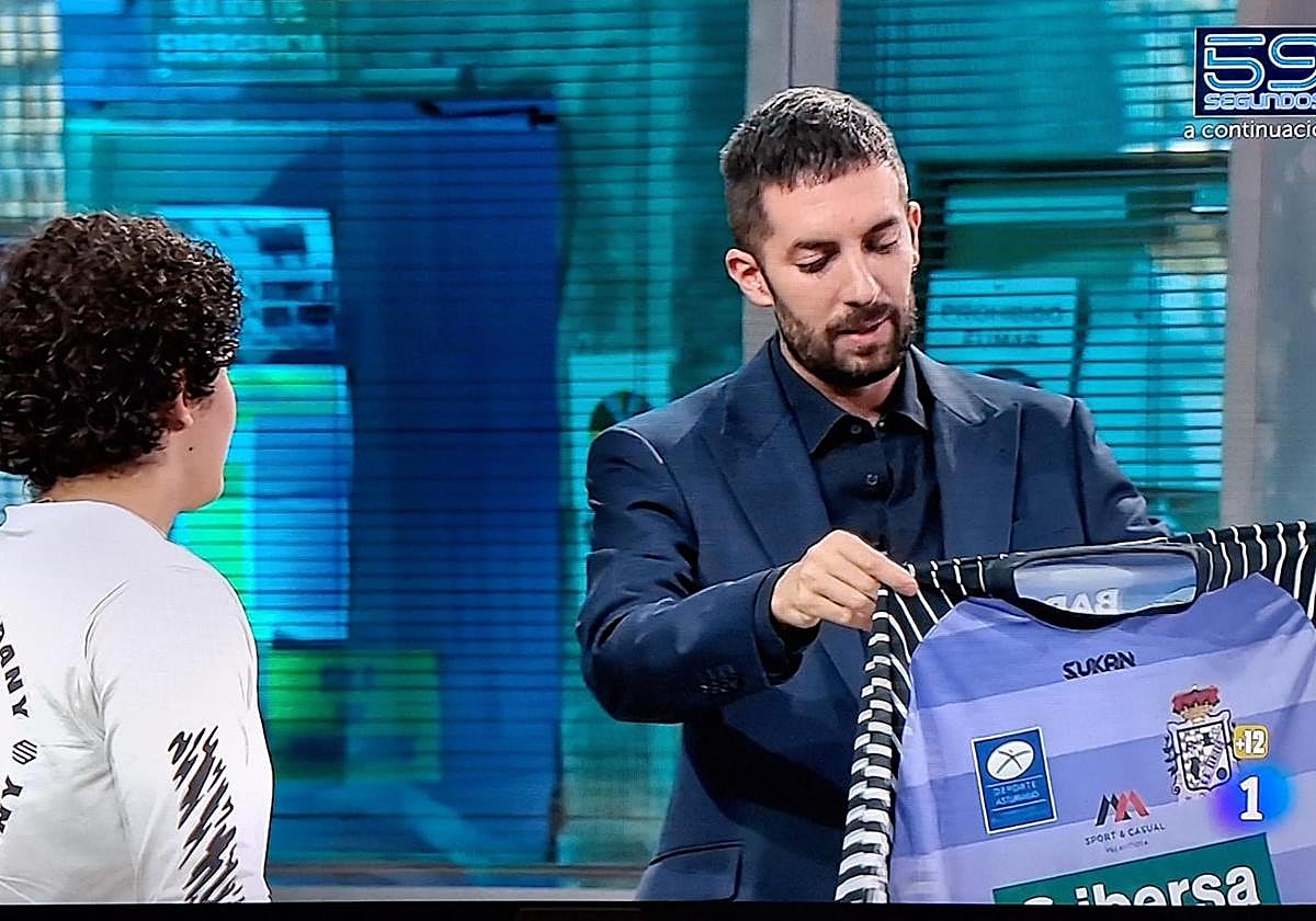 David Broncano muestra la camiseta del Sariego que le regaló la luchadora asturiana Merche García.