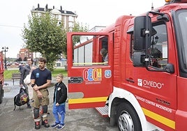 Dos niños descubren los entresijos de un camión de bomberos en La Corredoria.
