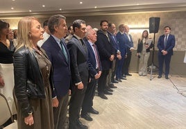 Feijóo, Moreno Bonilla, Manuel Quevedo, Álvaro Queipo, Carlos Paniceres, Pablo Junceda, Jacobo Cosmen y Mario Arias, durante la interpretación del Himno de Galicia y el de Asturias por la Banda de Gaitas de Oviedo.