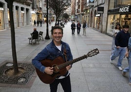 José Taboada, con su guitarra, en la calle Corrida de Gijón, tras una de sus actuaciones