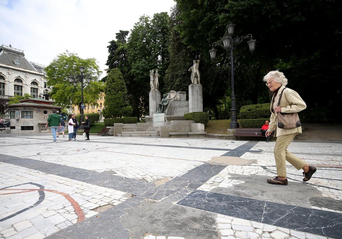 Una mujer pasa sobre uno de los parches de cemento del paseo de Los Álamos del Campo San Francisco.