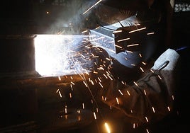 Un soldador trabaja en una pieza de metal.