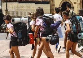 Un grupo de peregrinos ante la lona de la campaña 'Oviedo, origen del Camino', en la plaza de la Catedral.