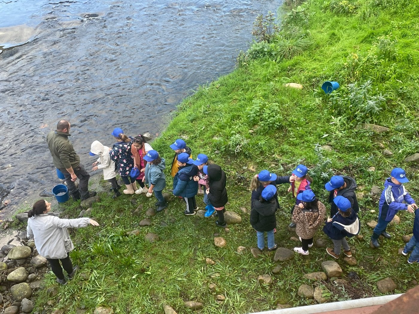 Un grupo de escolares, mientras esperaban su turno para coger los alevines de trucha y lanzarlos a las aguas del río Nalón.