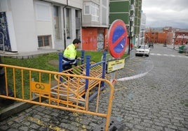 Un operario instala vallas, aún con vehículos estacionados en la zona afectada por las obras de la plataforma única de Cimavilla, en Gión.