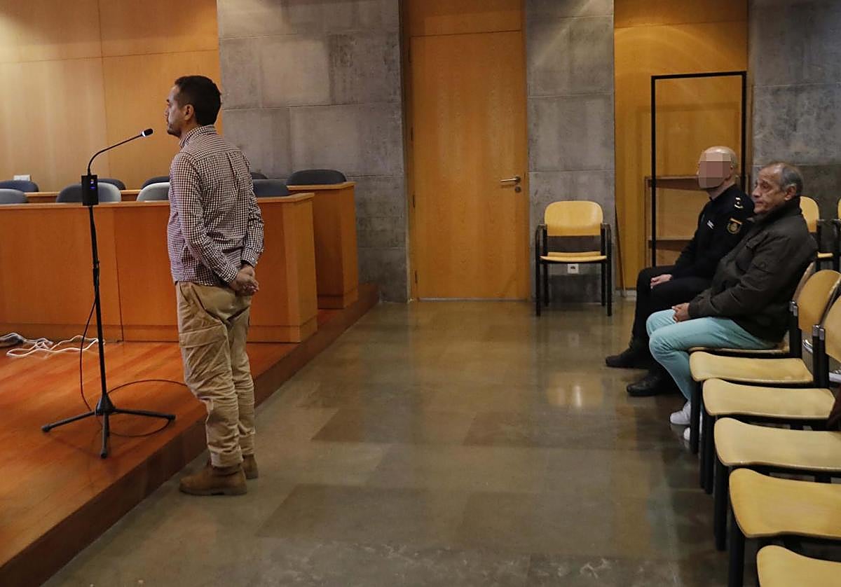 El condenado, sentado junto a un agente de la Policía Nacional, escucha declarar a su exyerno.