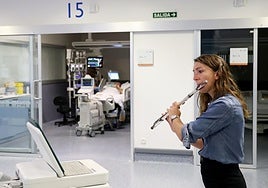 Mercedes Schmidt tocando la flauta en una de las salas del HUCA.