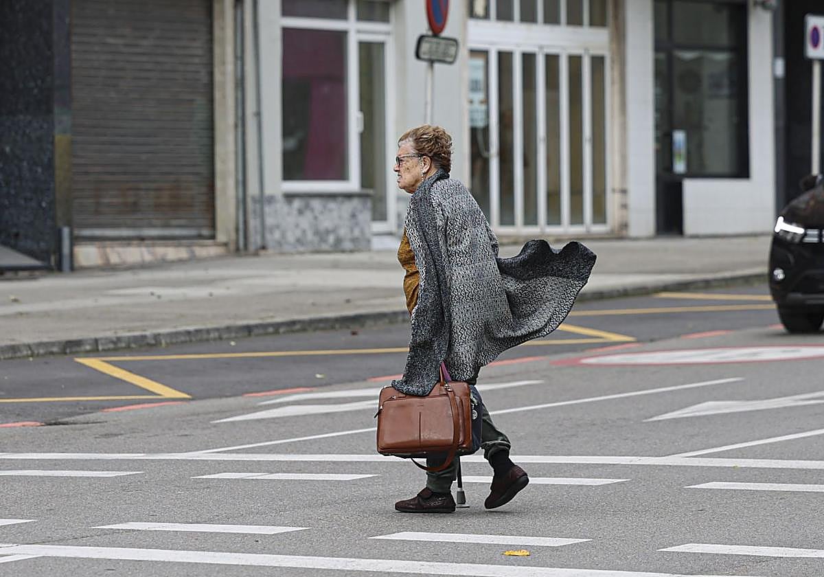 Una mujer cruza un paso de peatones en Avilés.