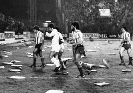 Los jugadores del Real Madrid y del Sporting abandonan el césped de El Molinón cubierto de almohadillas al finalizar el partido con empate a uno y que decidió la Liga para el equipo madrileño.