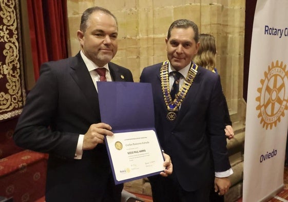 Carlos Paniceres, presidente de la Cámara de Comercio de Oviedo, sujeta el diploma acreditativo del premio que recibió de manos del presidente del Rotary Club, José Piloñeta.