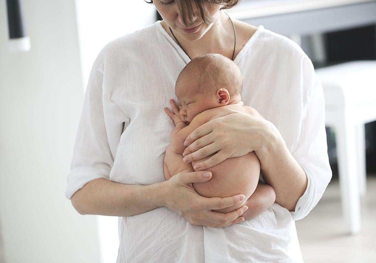 Una mujer sostiene a su bebé.
