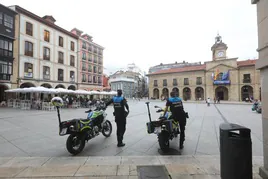 Dos policías locales, junto a sus motos, vigilan la Plaza de España.