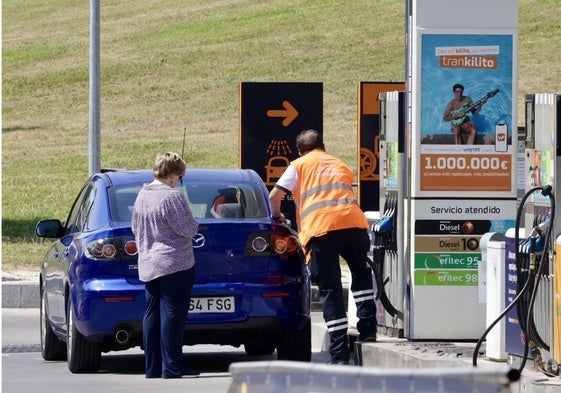 Una conductora reposta combustible en una estación de servicio.