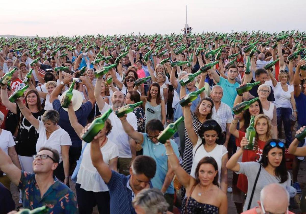 Personas, en la playa de Poniente, donde se lleva a cabo el multitudinario escanciado.