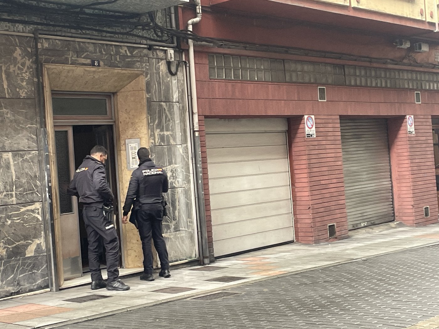 Agentes de la Policía Nacional, el domingo, custodiando el portal donde ocurrió el trágico suceso.