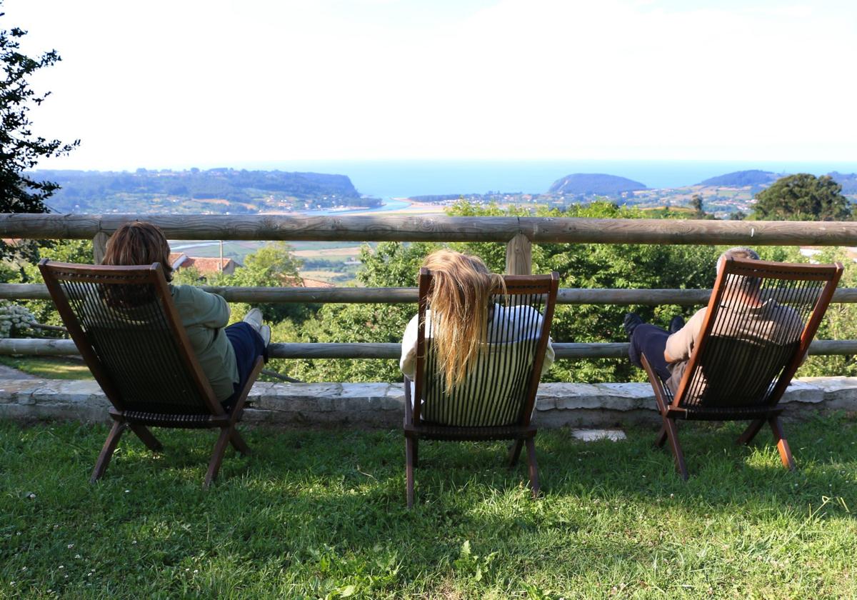 Una pareja disfruta de las vistas desde la parcela de un alojamiento rural asturiano.