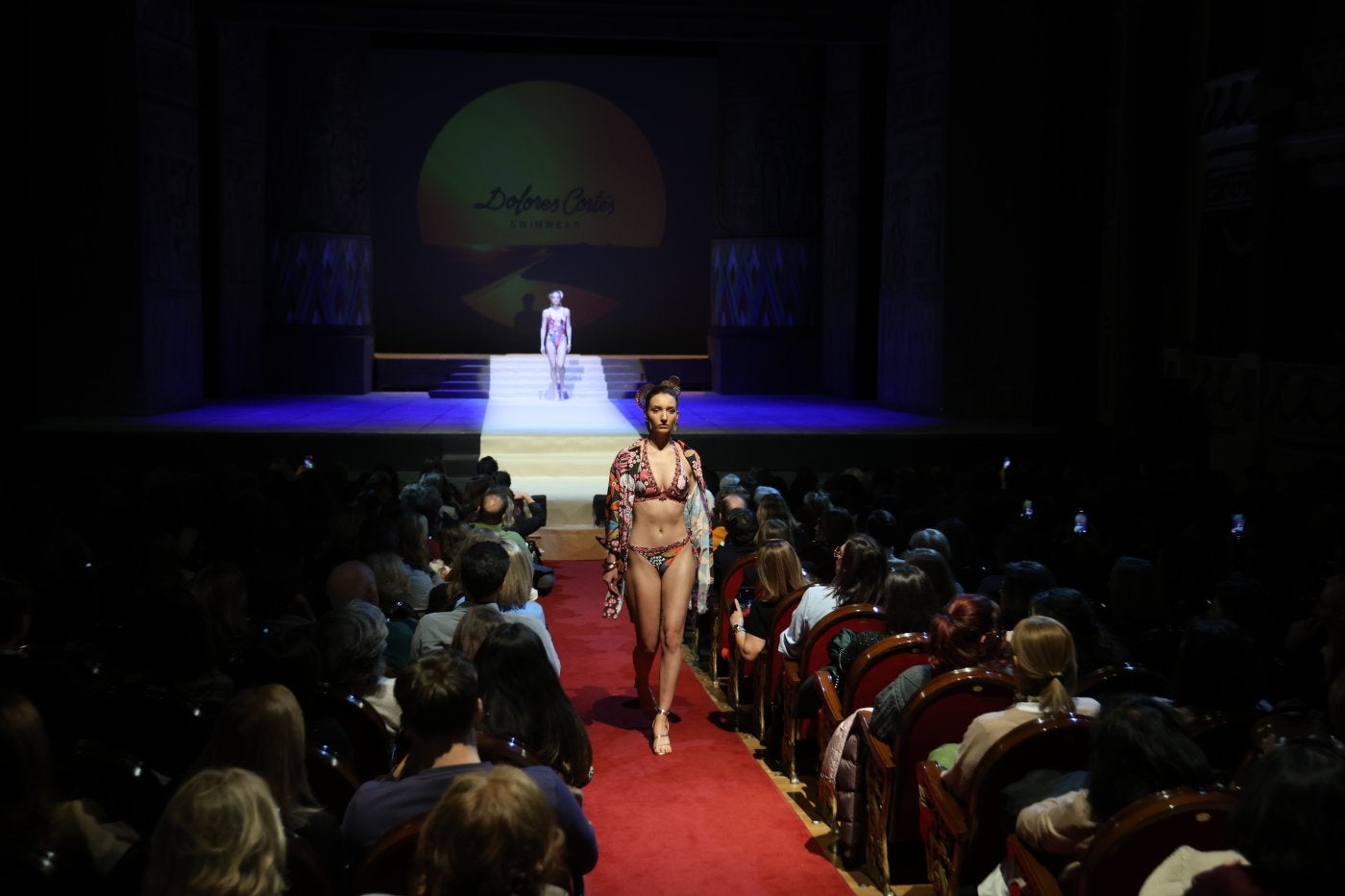 Una modelo, en la pasarela del patio de butacas durante el desfile de moda de baño 2025 de Dolores Cortés.