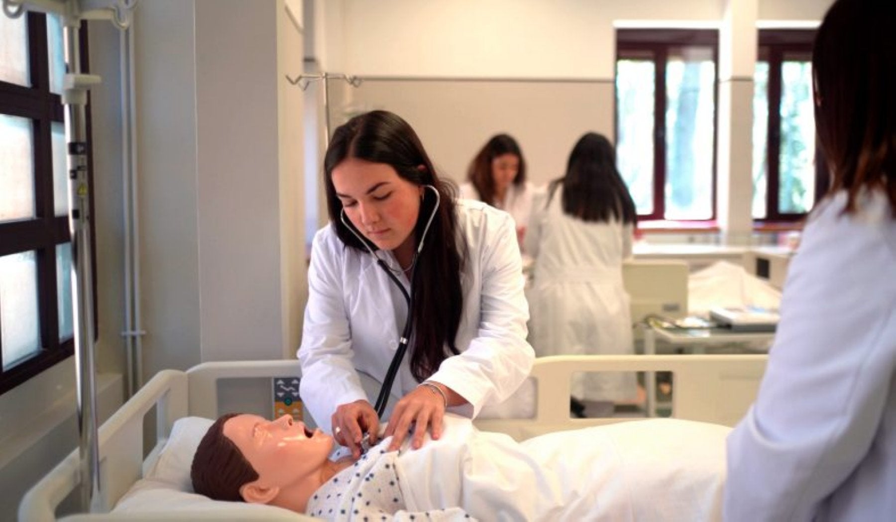 Una estudiante de la Nebrija practica con un muñeco.