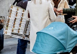 Varias personas compran décimos de Lotería de Navidad.