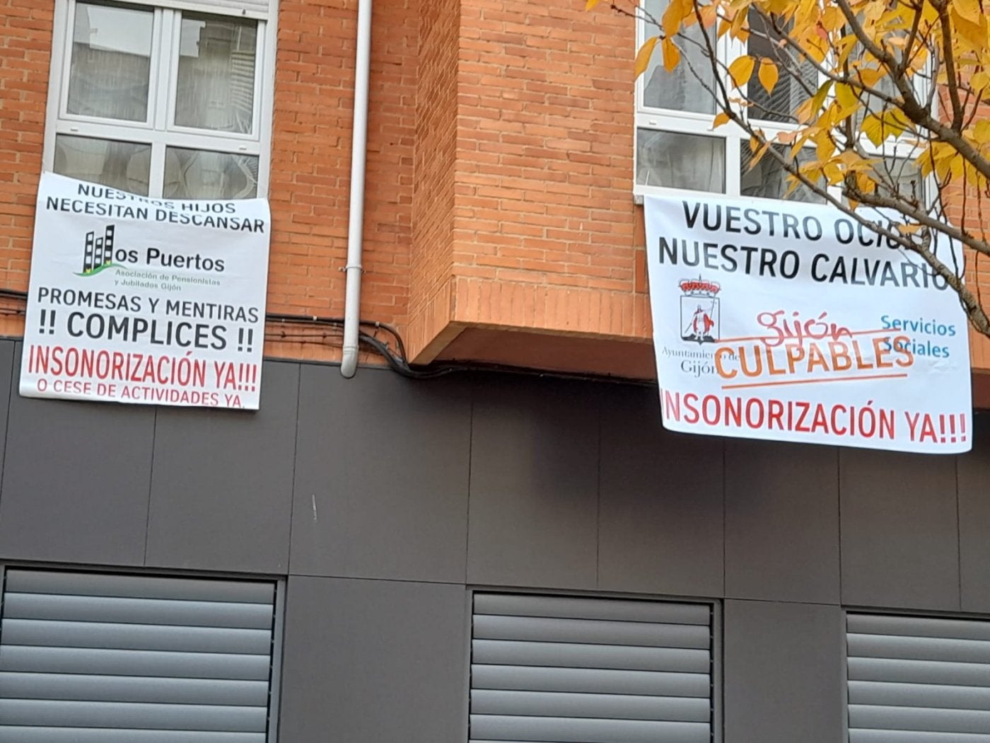Pancartas de protesta contra el ruido que genera el bajo de la entidad vecinal de pensionistas colocado en el primer piso de la calle Puerto Leitariegos, 13, en Perchera.
