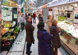 Varios compradores aguardan su turno en el Mercado del Sur, de GIjón.