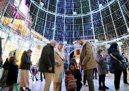 Una familia disfruta de las luces de Navidad en Oviedo.