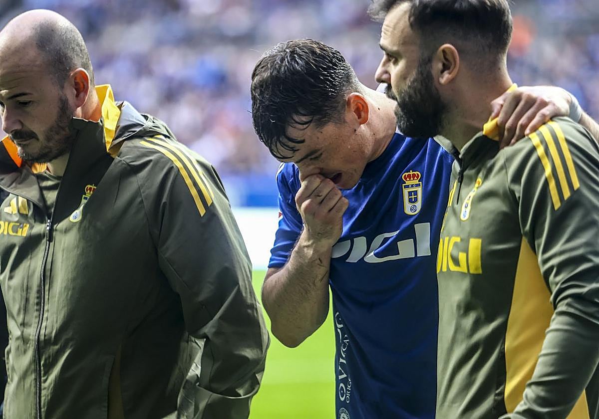 El fisio del Real Oviedo Gabri Díaz y el doctor David Bonilla acompañan a Fede Viñas al abandonar en campo.