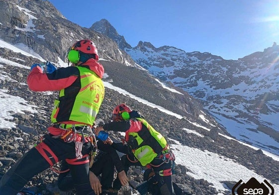 Dos efectivos del Servicio de Emergencias del Principado de Asturias atienden al joven al que se le buscaba en Picos de Europa.