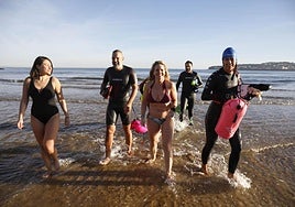 Un grupo de habituales tras el primer baño del año en la playa de San Lorenzo