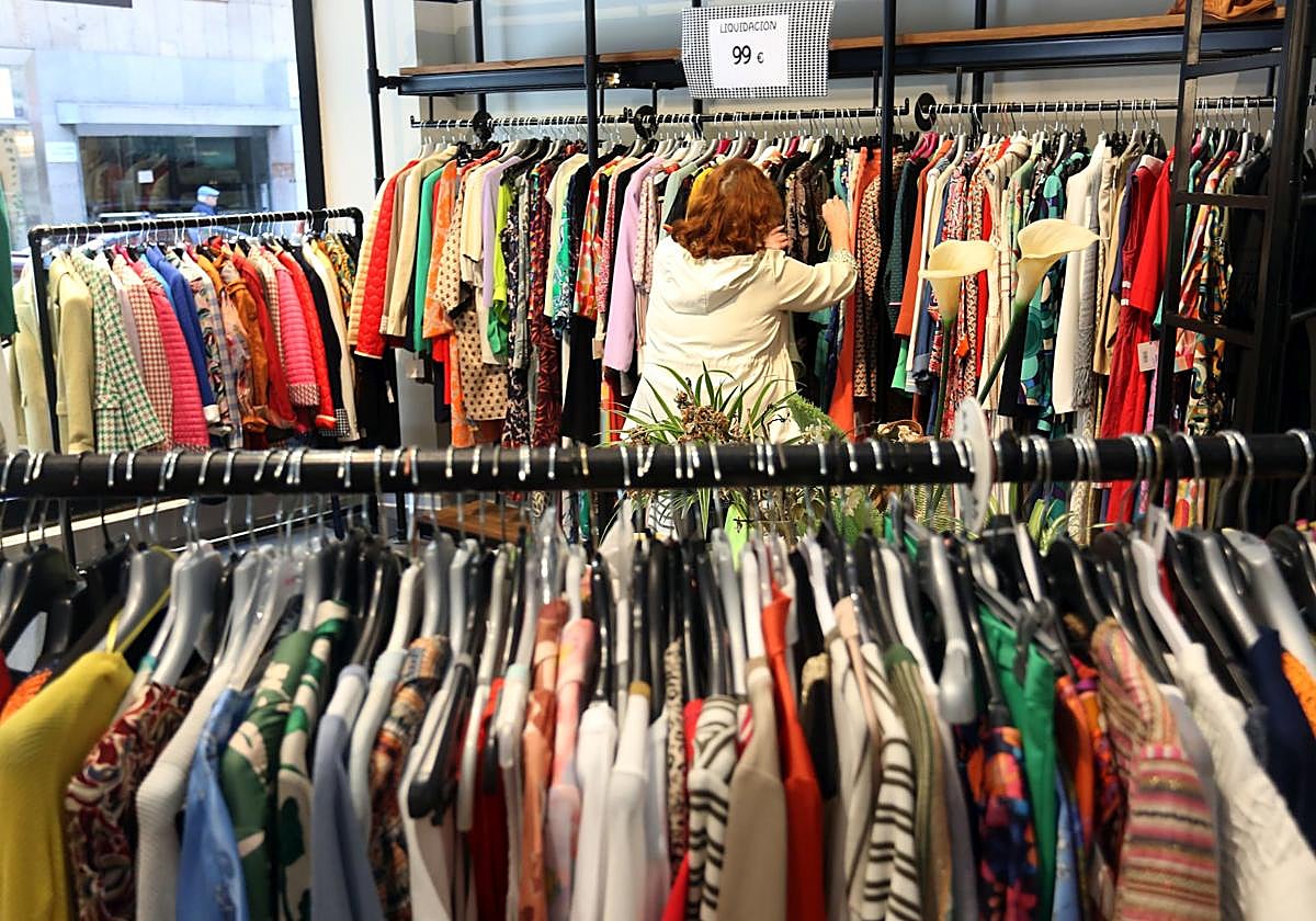 Una mujer mira ropa en una tienda.